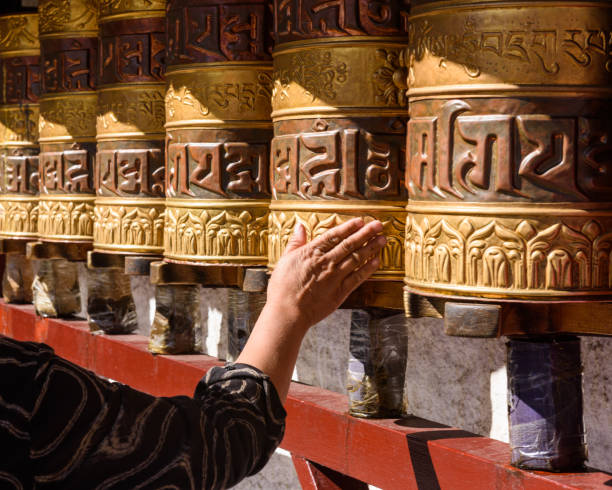 as rodas da oração e da oração no templo de jokhang. os personagens (na língua newari e tibetano) sobre as rodas são os mantras "om mani padme hum", cada palavra significa "sagrado, talão, flor de lótus, espírito de iluminação" - tibetan script fotos - fotografias e filmes do acervo