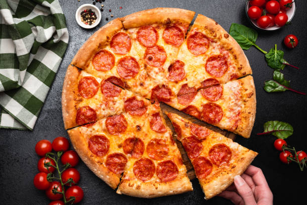 pizza de pepperoni sobre un fondo de hormigón negro - pizza de chorizo fotos fotografías e imágenes de stock
