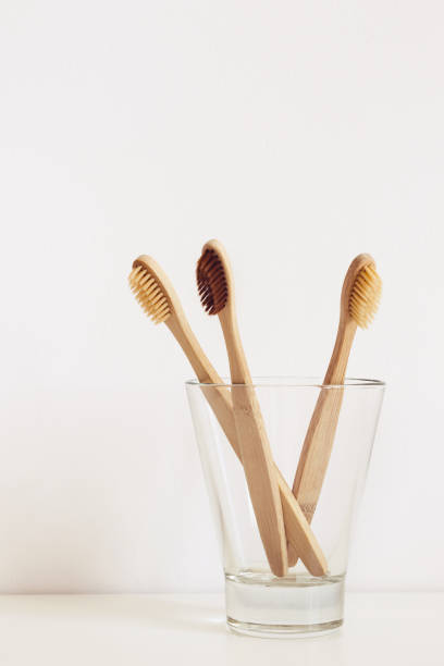istock Three bamboo toothbrushes with natural bristles in glass 1142751633