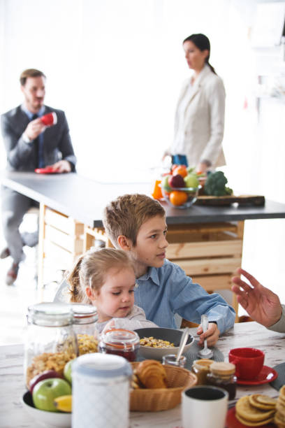 istock Children having breakfast, parents drinking morning coffee in the kitchen 1142752966