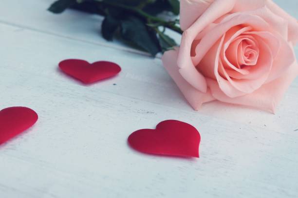 belleza rosa-naranja rosa y rojo satén corazón forma en el suelo de madera. concepto de fondo del día de san valentín. - orange rose candy valentines day fotografías e imágenes de stock