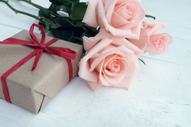 una caja de regalo en el suelo de madera blanca con belleza suave rosas pastel. concepto de fondo del día de san valentín. - orange rose candy valentines day fotografías e imágenes de stock