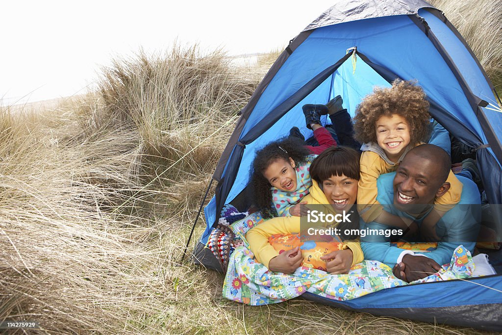 Giovane famiglia rilassante vacanza in campeggio tenda all'interno - Foto stock royalty-free di Famiglia