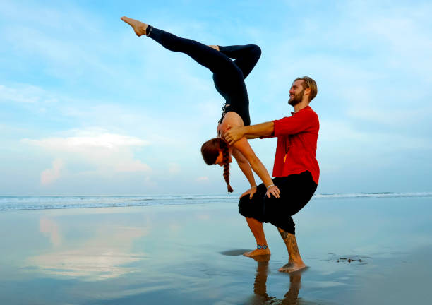 istock young attractive and beautiful acrobat couple practicing acroyoga exercise concentrated keeping balance practicing yoga on the beach in relaxation and meditation concept and healthy lifestyle 1142760107