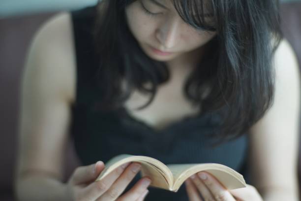 istock Young woman reading at home 1142761494