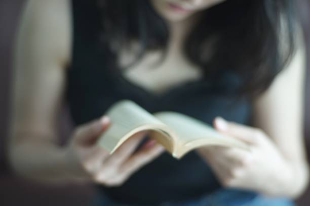 istock Young woman reading at home 1142761506
