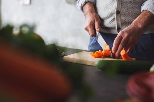 close up of man cutting carrot - vegetable men cutting adult imagens e fotografias de stock