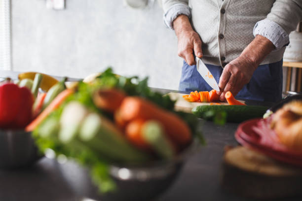 istock Man cutting carrot in the kichen 1142761961