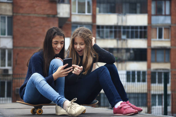 istock Two friends sitting on a skateboard 1142764453