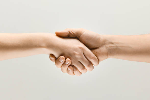istock Two male hands shaking isolated on grey studio background 1142764759