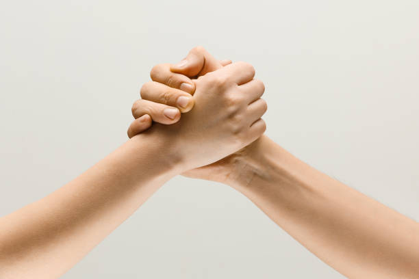 dwie męskie ręce rywalizują w arm wrestlingu izolowanym na szarym tle studia - wrestling sport conflict competition zdjęcia i obrazy z banku zdjęć