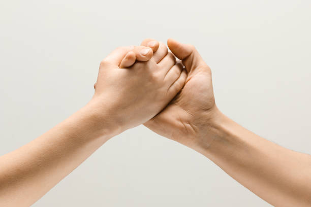istock Two male hands competion in arm wrestling isolated on grey studio background 1142764761