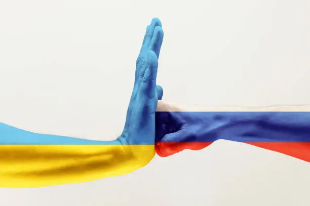 Stop the brother's hit. Two male hands fighting colored in Russian Federation and Ukraine flags isolated on white studio background. Concept of political, economical, social aggressions, disagreement.