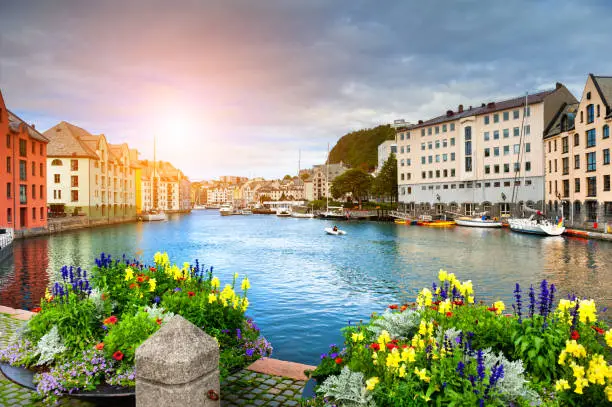 Beautiful promenade with flowers on the canal in Alesund, Norway. Famous tourist destination