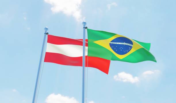 istock Austria and Brazil, two flags waving against blue sky 1142769000