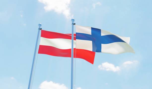 istock Austria and Finland, two flags waving against blue sky 1142769061