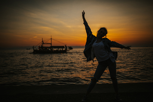 Young woman enjoying sunset at seaside
