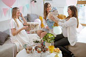 Pregnant woman holding dressed teddy bear on baby shower