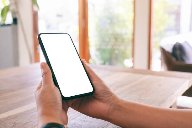 istock Mockup image of woman's hands holding black mobile phone with blank white screen in cafe 1142771226