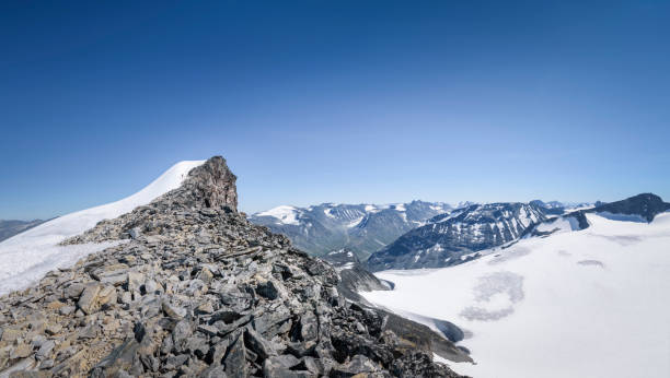 turysta w pobliżu szczytu góry w wielkiej panoramie parku narodowego jotunheimen noway - noway zdjęcia i obrazy z banku zdjęć