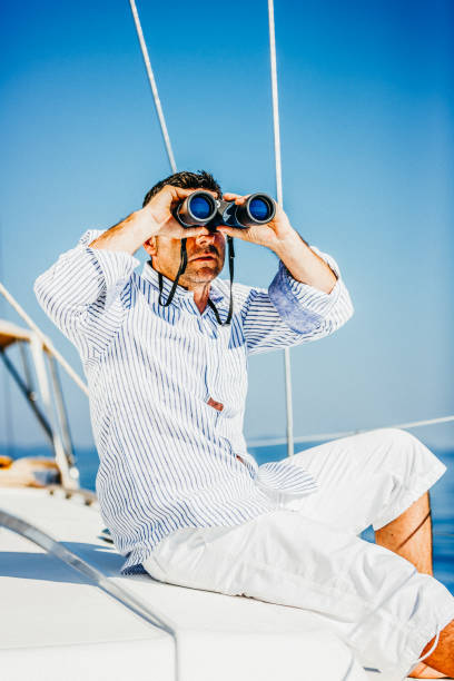 istock Handsome man with binoculars on sailboat 1142772209