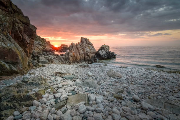 Amazing sunset in the sea with the rocky and harsh coast cliff of Kullaberg nature reserve