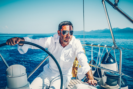 Handsome man sailing with sailboat.