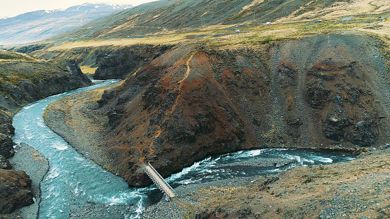 Aerial view of turquoise river winding among rocks