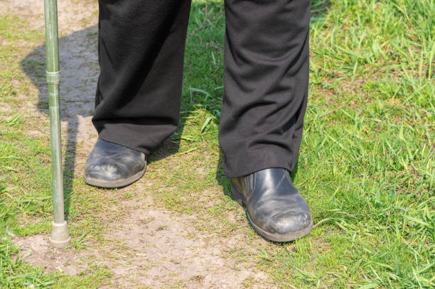 istock Man with walking stick wearing old scratched shoes walking on a path 1142773290