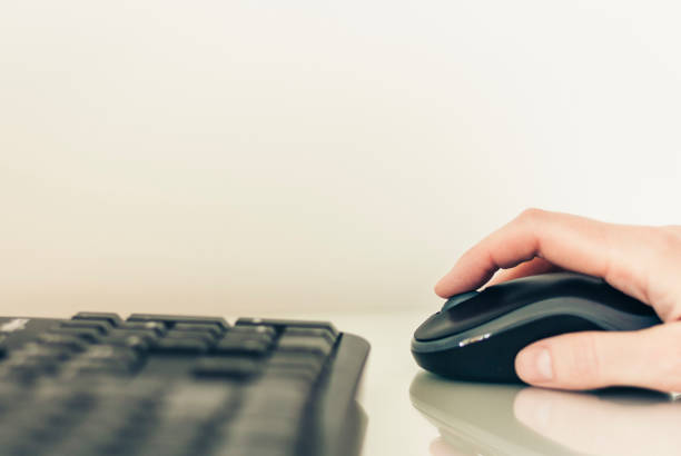 istock Close-up of hand woman using a mouse and typing on keyboard computer on glass table, business concept 1142773522