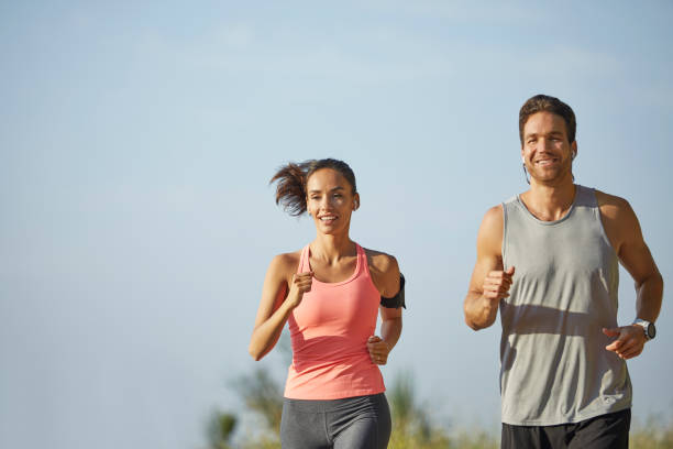 istock Smiling couple jogging at park against sky 1142775666