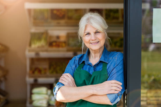 Portrait of confident owner with arms crossed standing in small grocery store Portrait of confident owner with arms crossed standing in small grocery store farmers market healthy lifestyle choice people stock pictures, royalty-free photos & images