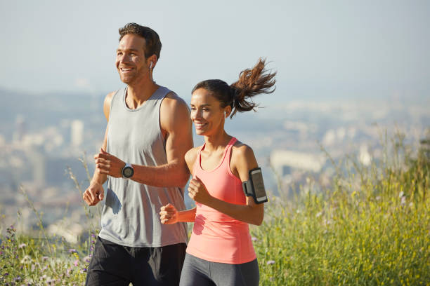 istock Happy couple jogging at park during sunny day 1142775794