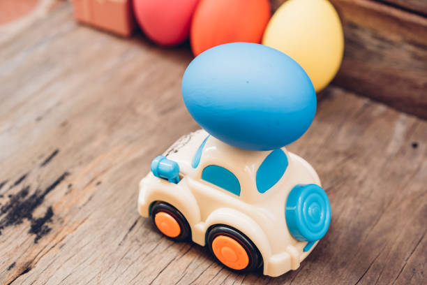 istock Easter egg and toy car on wooden background 1142776624
