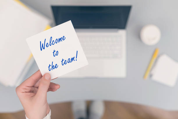woman clerk sitting holding note paper sticker with welcome to the team phrase. business concept. concept. - onboarding imagens e fotografias de stock