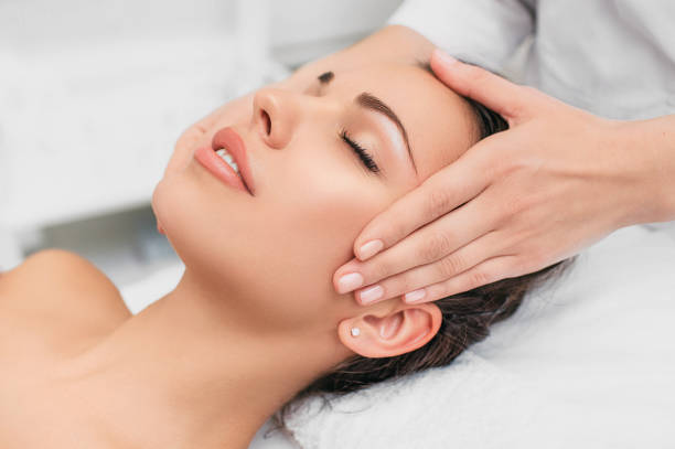 giovane donna farsi massaggiare la testa in un centro benessere di bellezza. rilassati con il massaggio alla testa - head massage massaging beauty treatment massage therapist foto e immagini stock