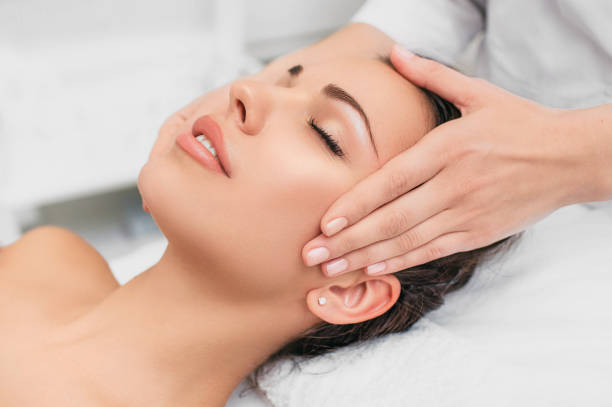 young woman getting head massaged at a beauty spa. Relax with head massage Beautiful woman enjoying in head massage during beauty treatment in the spa. facial massage stock pictures, royalty-free photos & images