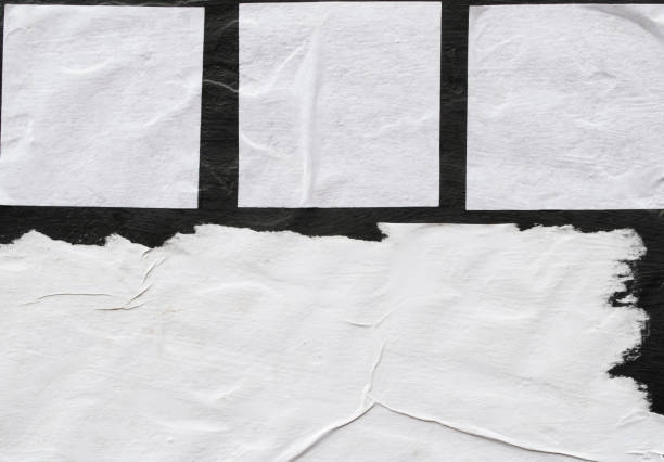 istock Several sheets of white paper pasted on a black wall. 1142787953