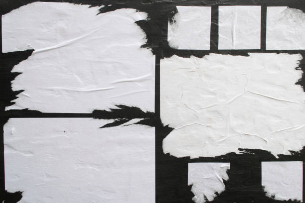istock Several sheets of white paper pasted on a black wall. 1142788209