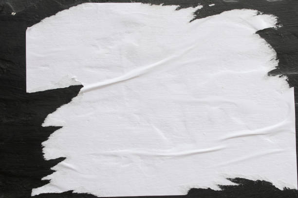 istock A sheet of white paper glued on a black wall. 1142788306
