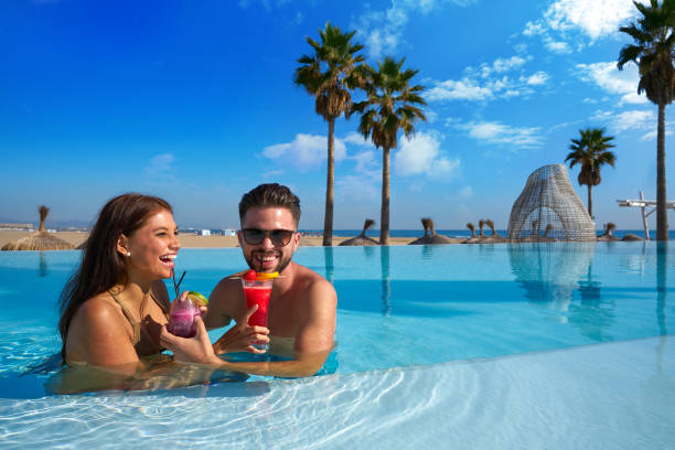 pareja de turistas que tienen baño en la piscina infinita - honeymoon beach swimming pool couple fotografías e imágenes de stock