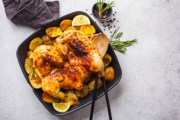 istock Fried whole tabaka chicken with potatoes in a grill pan, top view, white background. 1142790693