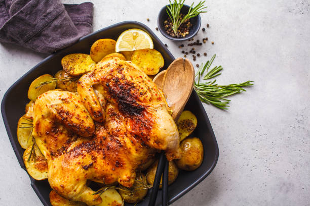 istock Fried whole tabaka chicken with potatoes in a grill pan, top view, white background. 1142790714