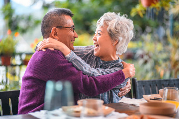 istock Smiling senior couple embracing at dining table 1142791447