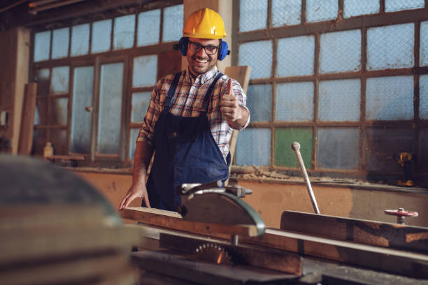 istock Carpenter posing on his workplace in carpentry workshop - Happy Carpenter 1142791625