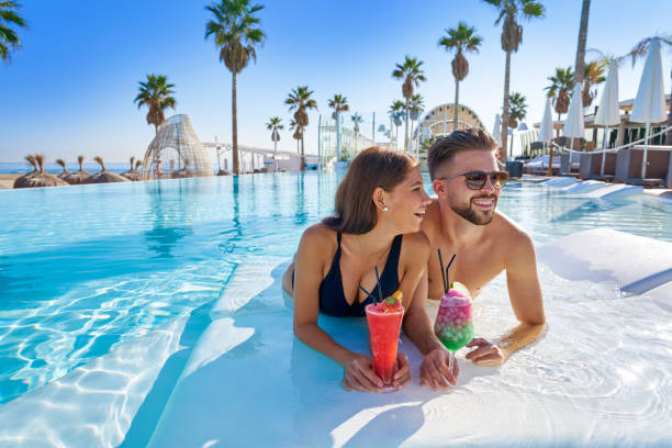 istock Young couple on infinity pool with cocktails 1142792551