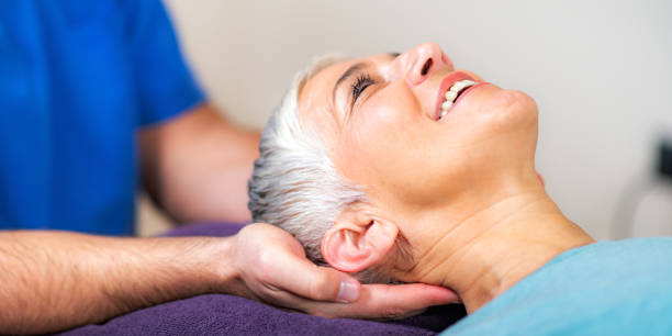 Physical Therapist Working with Neck. Senior Woman