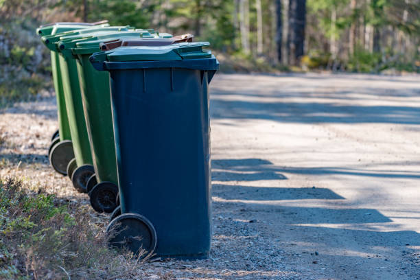 Trash cans standing beside a gravel road