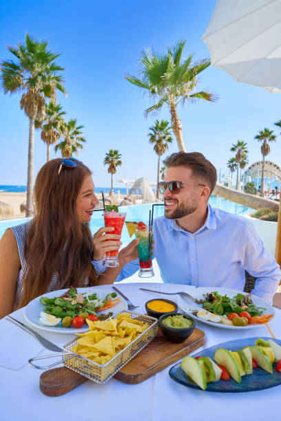 istock Young couple with cocktails in pool restaurant 1142794404