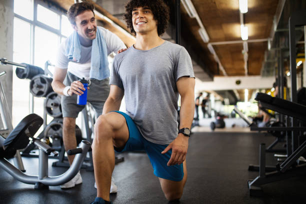 istock Young fit handsome man doing exercises in gym 1142796143